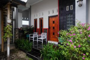 a house with a porch with chairs and flowers at RedDoorz at Jalan Dieng 3 in Wonosobo