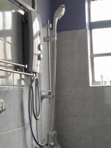 a shower in a bathroom with a shower head at Hirwado Homes in Nairobi