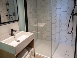 a bathroom with a sink and a shower at Greet Hôtel Orthez Bearn in Orthez