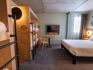 a hotel room with a bed and a desk at Greet Hôtel Orthez Bearn in Orthez