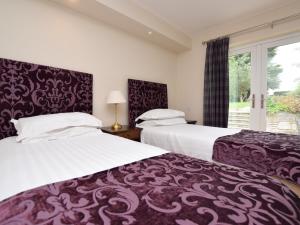 2 Bed in Edinburgh 83967 في روزلين: سريرين في غرفة مع نافذة