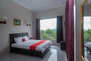 a bedroom with a bed and a large window at RedDoorz at Jalan Dieng 3 in Wonosobo