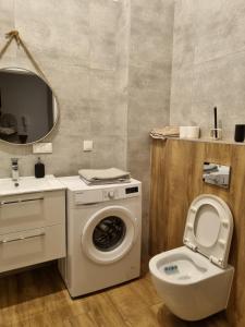 a bathroom with a washing machine and a toilet at Rukadel - Tadeusza Kościuszki in Wrocław