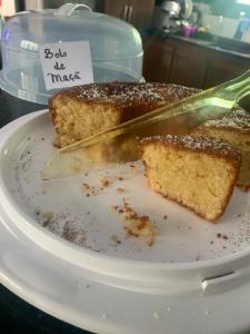 un trozo de pastel en un plato con un cuchillo en Kionda Surf House en Bertioga
