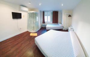 a bedroom with two beds and a walk in shower at Habitación cerca del centro in Valencia