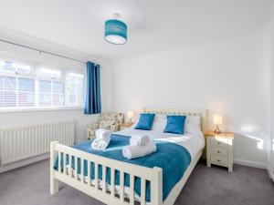 a bedroom with a white bed with blue accents at 4 Bed in Brockenhurst 80420 in Brockenhurst