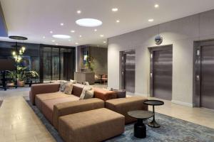 a large living room with a couch and tables at Vienna House by Wyndham zur Bleiche Schaffhausen in Schaffhausen