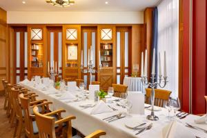 a large dining room with a long table and chairs at Vienna House by Wyndham Sonne Rostock in Rostock