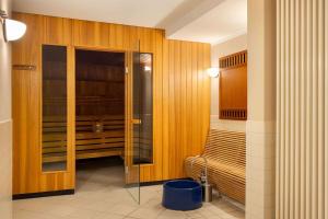 ein Bad mit einer ebenerdigen Dusche und Holzwänden in der Unterkunft Vienna House by Wyndham Sonne Rostock in Rostock