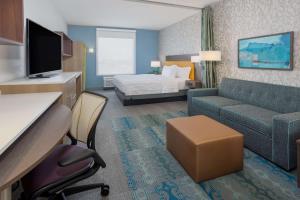 a hotel room with a bed and a couch at Tru By Hilton Pensacola Airport Medical Center in Pensacola