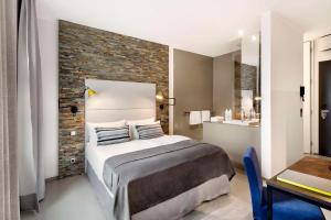 a bedroom with a bed and a brick wall at Lux 11 Berlin-Mitte in Berlin