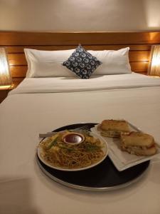 a tray with a plate of food on a bed at Subha Casa Hotel in Pātan