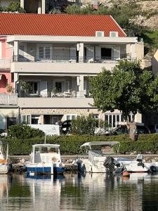 two boats docked in the water in front of a house at Harbour View House in Zaton