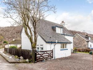 um chalé branco com uma cerca e uma árvore em 3 Bed in Glencoe 80624 em Glencoe