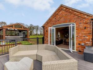 a brick building with a couch on a deck at 2 Bed in Audlem 81106 in Audlem