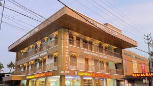 a large building with people on the balconies of it at Chittinappilly Cottage in Angamali