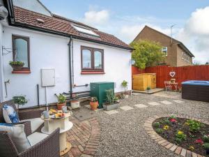 a backyard with a white house with a garden at 1 Bed in Nr. Rothbury 82147 in Longhorsley