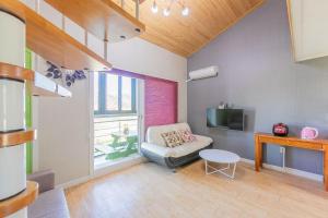 een woonkamer met een bank en een tv bij Suncheonbay Reed Field Pension in Suncheon