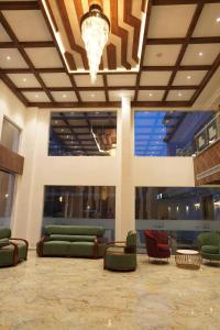 a lobby with couches and chairs and a chandelier at HOTEL VKJ INN Aluva in Alwaye