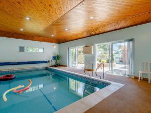 a swimming pool in a house with a wooden ceiling at 4 Bed in Netley 82920 in Netley