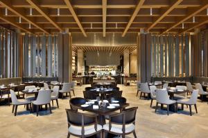 a restaurant with tables and chairs and a bar at Indore Marriott Hotel in Indore