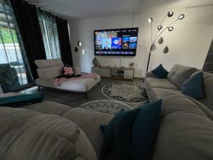 Una sala de estar con un sofá y un televisor. en La villa Loca Reunion, en Saint-Joseph