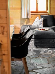 una sedia nera in un soggiorno con divano di Alpin-Hütten auf der Turracherhöhe - Haus Fuchs by S4Y a Turracher Hohe