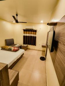 a small room with a bed and a tv at Ambassador Hotel in Guwahati