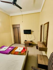 a bedroom with a bed and a flat screen tv at Ambassador Hotel in Guwahati
