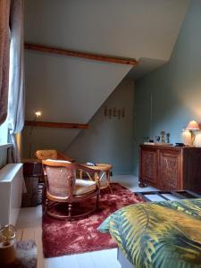 a bedroom with a bed and a table and a chair at Via Caput in Lokeren