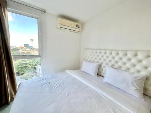 een slaapkamer met een groot wit bed en een raam bij Town Sukhumvit 71 in Bangkok