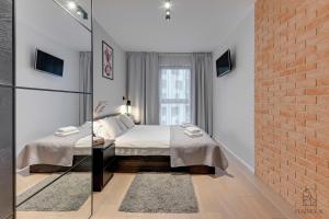 a bedroom with a bed and a brick wall at City Center SPA Apartments Jaglana 6E,F in Gdańsk