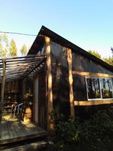 a log cabin with a porch and a deck at Cabaña en el bosque de Chiloé in Quemchi