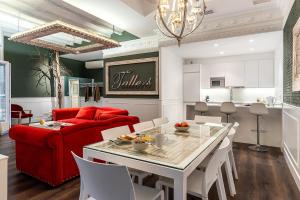 バルセロナにあるEnjoybcn Tallers Apartmentのリビングルーム(赤いソファ、テーブル付)