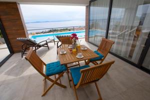 d'une table à manger et de chaises avec vue sur l'océan. dans l'établissement Luxury villa Astraeus 2 near Split, private pool, à Podstrana