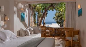 a bedroom with a bed and a view of the ocean at St. Nicolas Bay Resort Hotel & Villas in Agios Nikolaos
