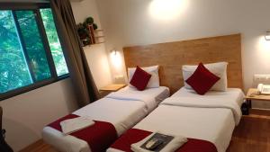 um quarto de hotel com duas camas com almofadas vermelhas em The Urban Stays em Hyderabad