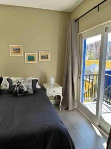 a bedroom with a bed and a balcony at Modern city townhouse with rooftop terrace in Cape Town
