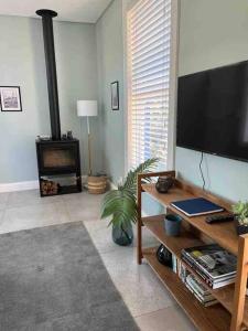 sala de estar con TV de pantalla plana y chimenea en Modern city townhouse with rooftop terrace, en Ciudad del Cabo