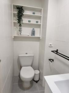 a white bathroom with a toilet and a sink at Jupiter2 Moderno estudio Parque La Paloma in Benalmádena