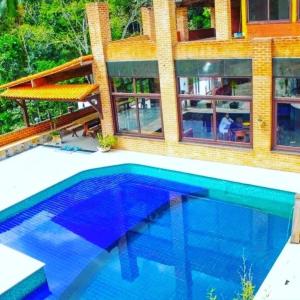 a swimming pool in front of a house at Pousada Som de Lumiar in Lumiar