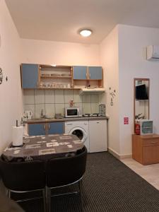 a kitchen with a table and a kitchen with a stove at Apartman Vitas in Slavonski Brod
