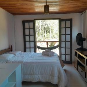 a bedroom with a bed and a large window at Pousada Som de Lumiar in Lumiar