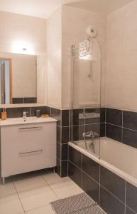 a bathroom with a tub and a sink and a shower at Nature Montagn view Salève Geneva - 12 pers. 2 logements in Beaumont
