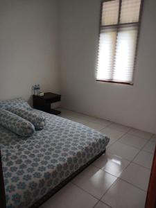 ein Schlafzimmer mit einem Bett, einem Tisch und zwei Fenstern in der Unterkunft Bumina EENK 