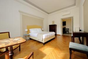 ein Schlafzimmer mit einem Bett, einem Tisch und einem Klavier in der Unterkunft Spanish Steps Family Home by TreasureRome in Rom