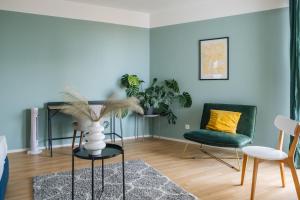 a living room with a plant and two chairs at Decorous cozy city view suite in Vienna