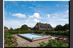 a house with a swimming pool in a yard at Haus Wattblick Meier W.O. in Braderup