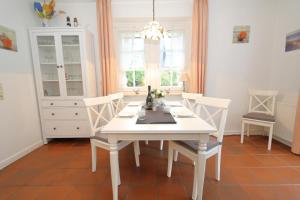 een witte eetkamer met een witte tafel en stoelen bij Südstrand 11 in Westerland