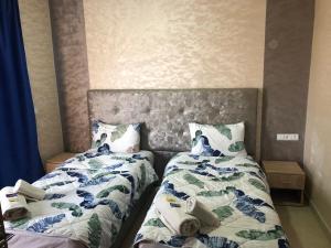 two beds sitting next to each other in a bedroom at Hotel Tidinit in Guelmim